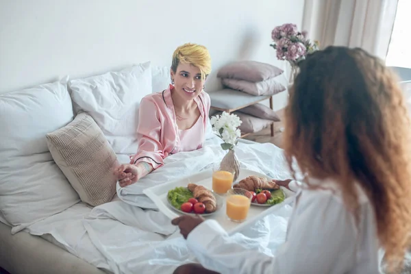 Femme heureuse au lit et petite amie avec petit déjeuner — Photo