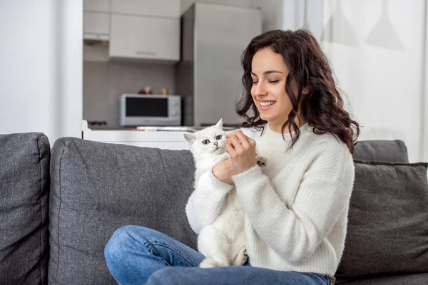 Hübsche junge Frau spielt mit ihrer Katze — Stockfoto