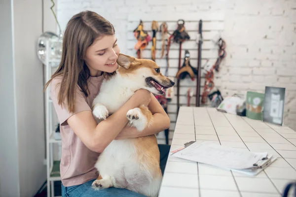 Fiatal nő kisállat tulajdonos gazdaság kutyája és érzés boldog — Stock Fotó