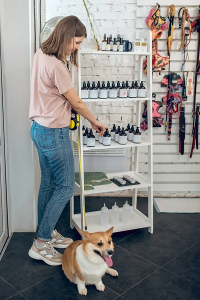 Linda chica joven con su perro pasar tiempo en una tienda de mascotas —  Fotos de Stock