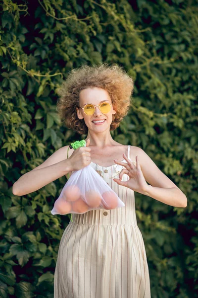 Giovane donna sorridente con una nettarine in mano sensazione incredibile — Foto Stock