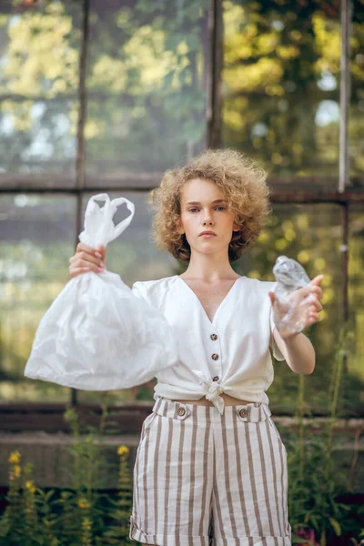 Curly-haired young woman protesting against plastic usage