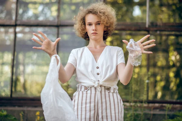 Curly-haired young woman protesting against plastic usage — Stock Photo, Image