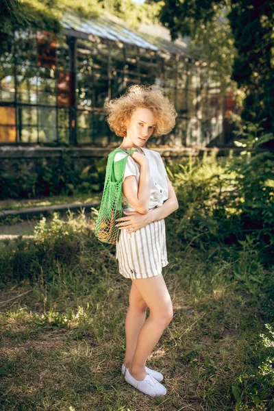 Кучеряве волосся молода жінка добре себе почуває в сонячний день — стокове фото