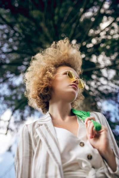 Ragazza dai capelli ricci in un parco dall'aspetto premuroso — Foto Stock