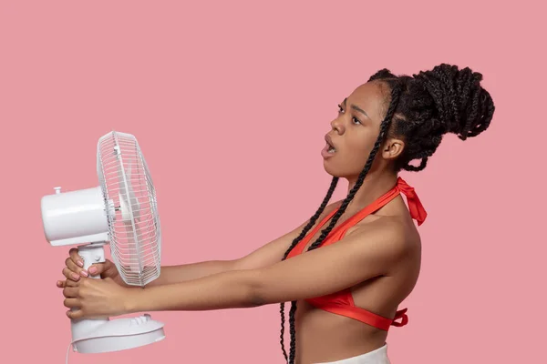 Leende afrikansk amerikansk kvinna håller en fläkt ser trött ut från värme — Stockfoto