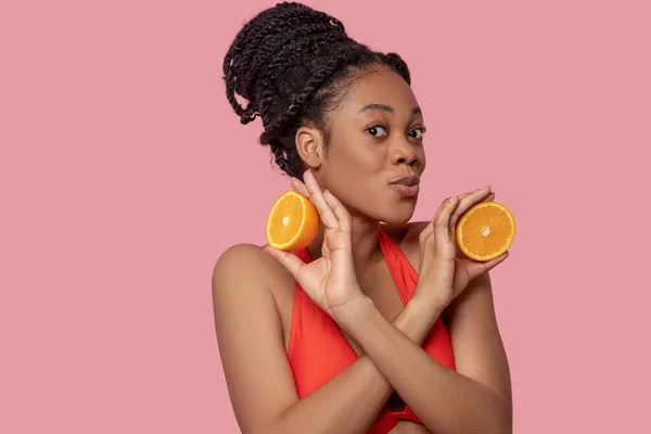 Mulher americana africana bonito com fatias de laranja nas mãos — Fotografia de Stock
