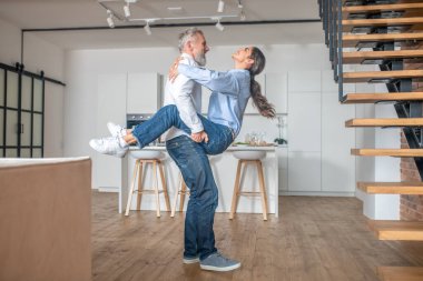 A happy couple having fun at home dancing and enjoying