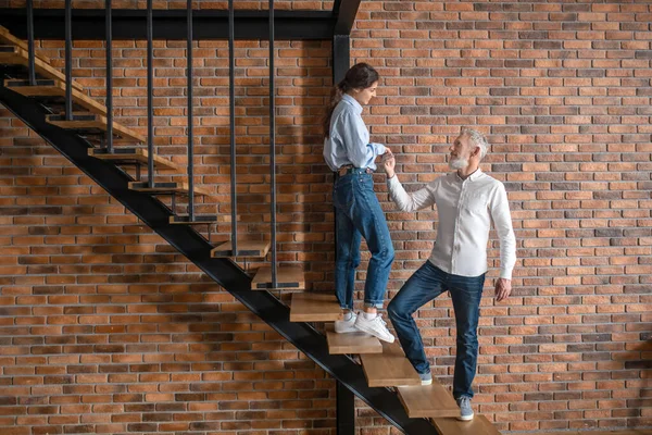 Um homem e uma mulher de pé nas escadas e a olhar um para o outro — Fotografia de Stock