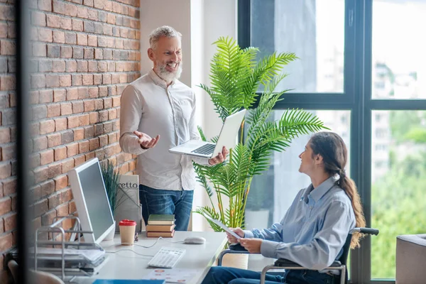 Gehandicapte jonge vrouw zit aan de tafel in het kantoor — Stockfoto