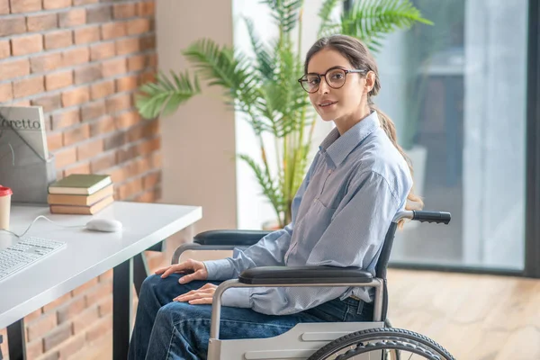 Young dark-haired handicapped woman looking thoughtful — Stock Photo, Image