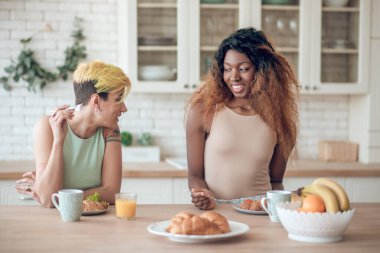 Sabahları mutfakta kahvaltı yapan iki kız arkadaş.