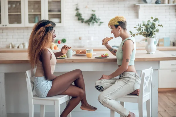 Karşılıklı yemek yiyen iki mutlu kız arkadaş. — Stok fotoğraf