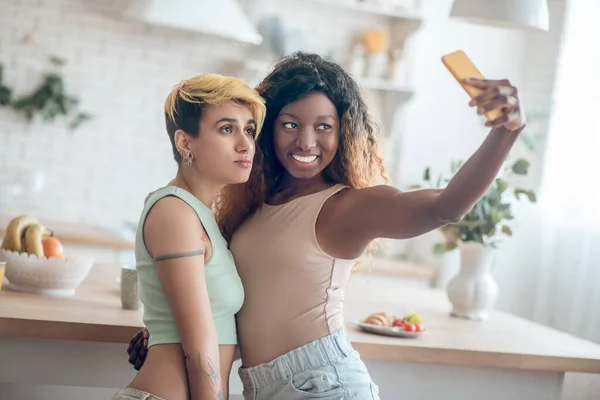 Düşünceli beyaz kadın ve koyu tenli kız arkadaş selfie çekiyorlar. — Stok fotoğraf