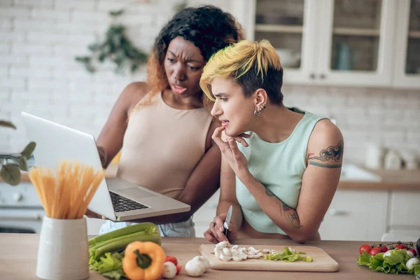 Emotionele ondervragende vriendinnen kijken verontwaardigd op laptop — Stockfoto