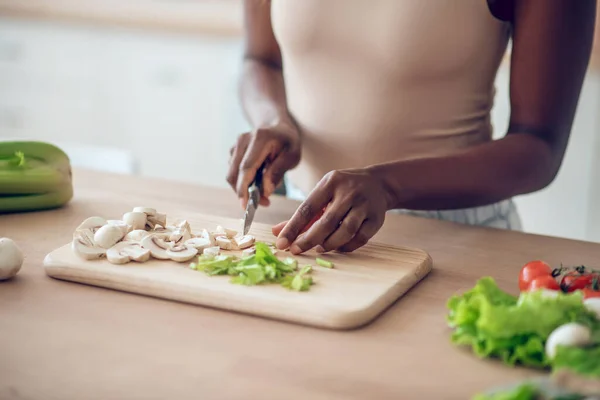 Руки афро - американських жінок рубають овочі ножем. — стокове фото