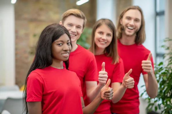 Afrikansk amerikansk flicka och vänner volontärer visar ok gest — Stockfoto