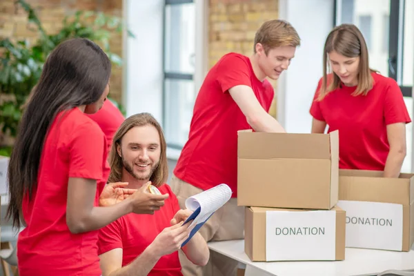 Gruppo di studenti volontari impegnati in un centro di beneficenza — Foto Stock