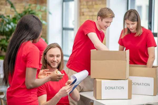 Grupo de estudiantes voluntarios comprometidos en el centro de caridad — Foto de Stock