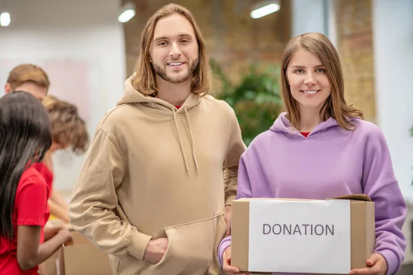 Guy a dívka s dárcovskou krabicí v sociálním centru — Stock fotografie