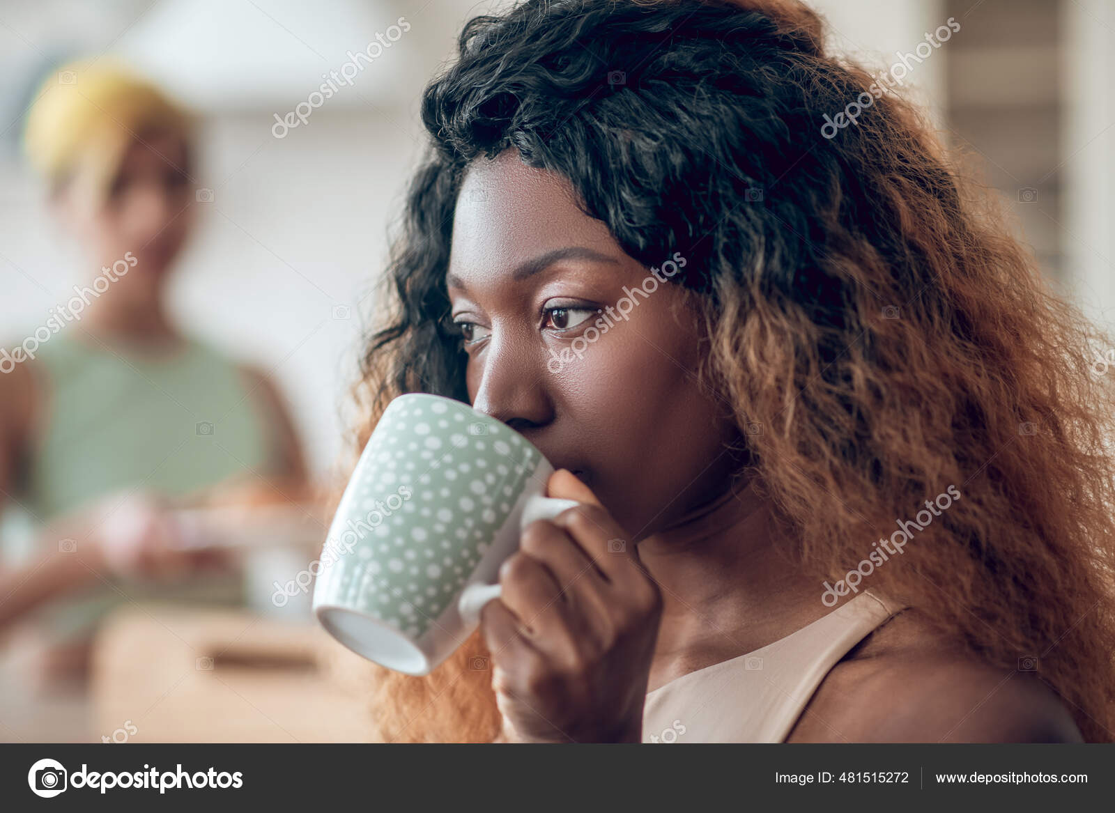 Close-up of a woman holding a cup of black coffee