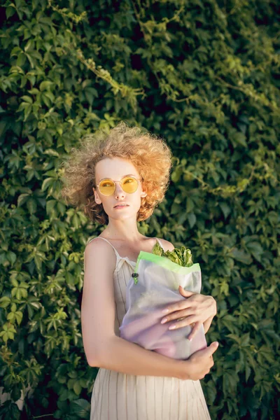 Joven mujer i sosteniendo una bolsa con verduras en sus manos — Foto de Stock