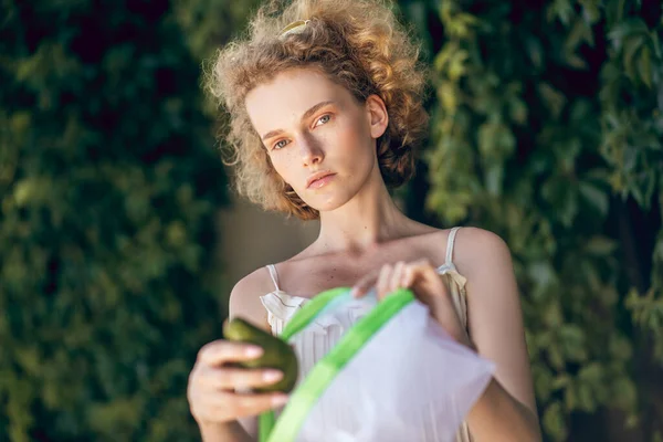 A picture of a young cute woman with a pack of veggies in her hands — Stock Photo, Image