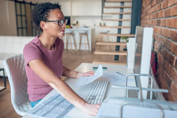 Женщина в очках работает за компьютером и выглядит занятой. — стоковое фото