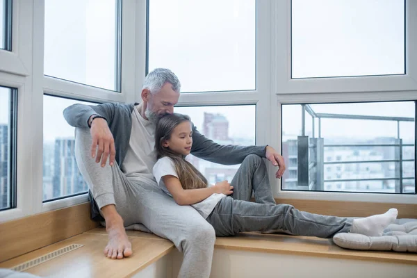 Un padre sentado en la ventana con su hija —  Fotos de Stock