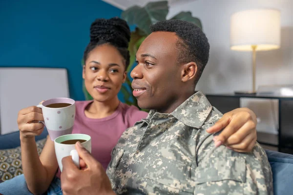 Vrouw knuffelen militaire man drinken koffie — Stockfoto