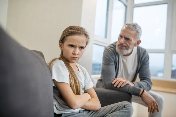 Hombre barbudo de pelo gris hablando con su hija y luciendo insatisfecho —  Fotos de Stock