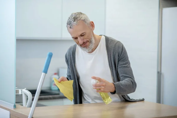 Hombre en ropa de casa haciendo tareas domésticas y buscando ocupado — Foto de Stock