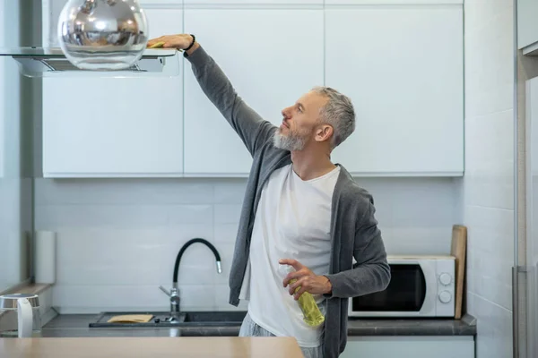 Hombre en ropa de casa haciendo tareas domésticas y buscando ocupado — Foto de Stock