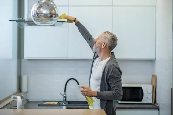 Man in huiskleding doet huishoudelijk werk en ziet er druk uit — Stockfoto