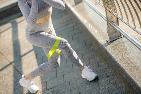 Ženské sportovkyně v šedém sportovním oblečení cvičení s páskou odporu — Stock fotografie