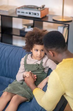 Babası elini tutuyor üzgün küçük kızı