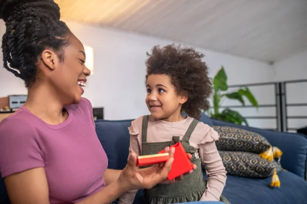 Riendo alegre mamá con caja abierta y buscando hija — Foto de Stock