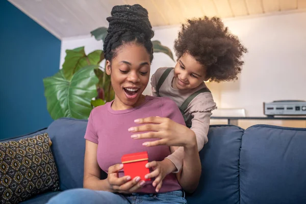 Enthousiaste Afrikaans-Amerikaanse vrouw en mooie dochter met geschenk. — Stockfoto