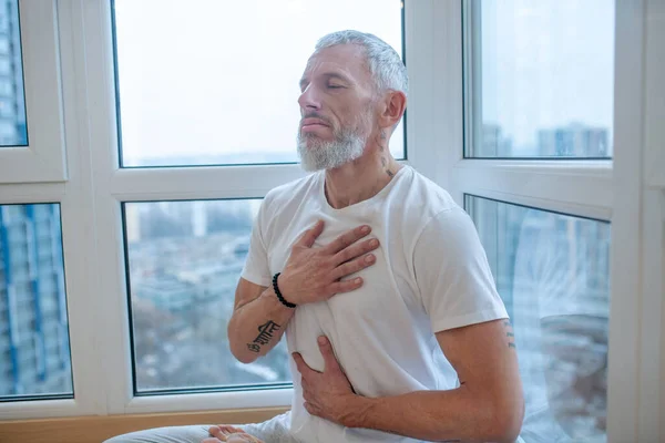 Dospělý jogín dělá pranayama a vypadá meditativně — Stock fotografie