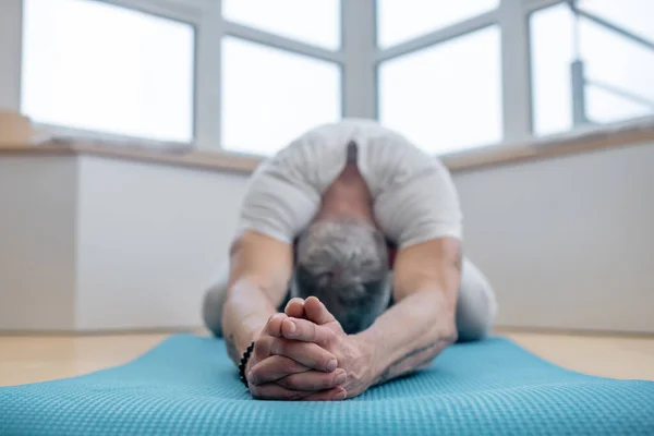 Ein reifer Yogi, der zu Hause übt und flexibel wirkt — Stockfoto
