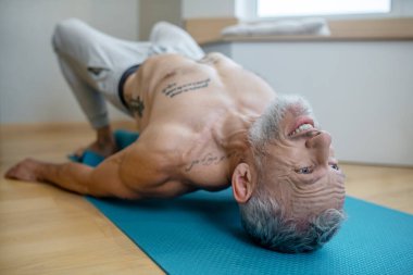 Yetişkin bir yogi evde egzersiz yapıyor ve Asana 'ya zorluk çıkarıyor..