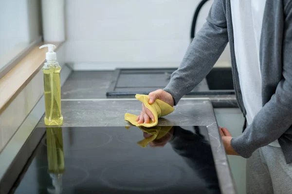 一个男人在厨房里擦桌子表面的特写镜头 — 图库照片