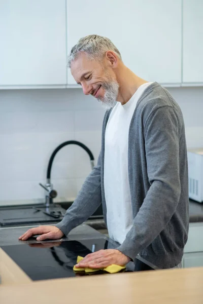 Homem de roupa de casa lavando os pratos na cozinha — Fotografia de Stock