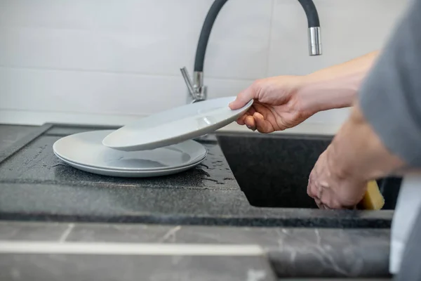 Um homem de cabelos grisalhos a limpar o frigorífico na cozinha — Fotografia de Stock