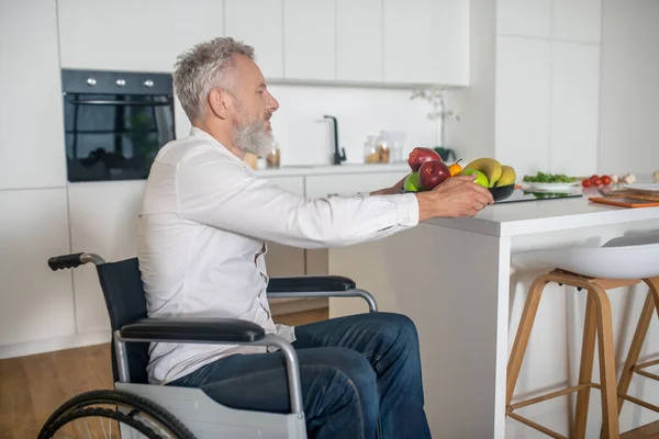 Hombre discapacitado de pelo gris en la cocina preparando el desayuno — Foto de Stock