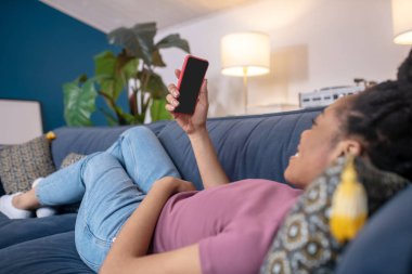 Kanepede selfie çeken Afrikalı Amerikalı kadın.