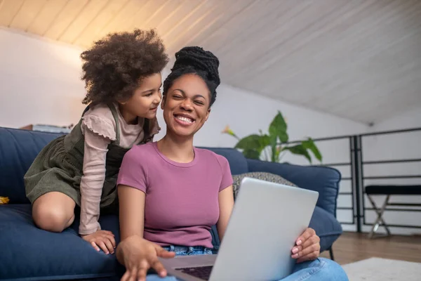 Mamá feliz con el ordenador portátil y la hija pequeña —  Fotos de Stock