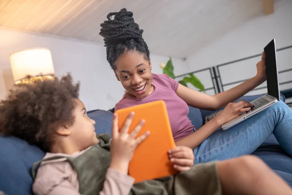 Klein meisje tonen tablet naar vreugdevolle moeder — Stockfoto