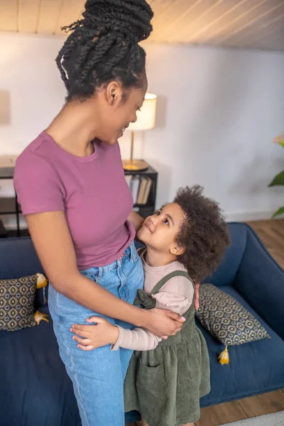 Klein meisje knuffelen kijken naar glimlachende moeder — Stockfoto
