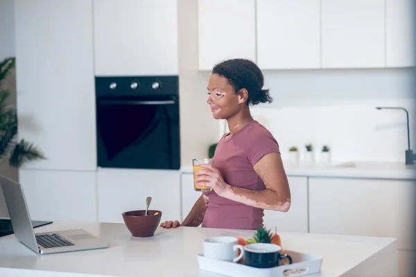 Joven mulata en la cocina viendo algo en internet — Foto de Stock